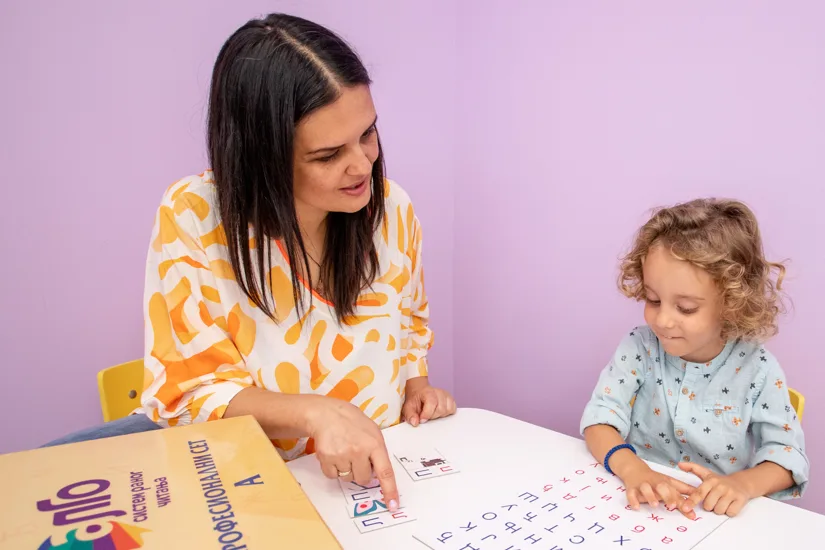 Devojčica i mentor uče slova i vežbaju čitanje – razvoj fonemske svesti uz ALGO set